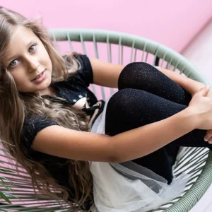 nastolatka w czarnych rajstopach z wiskozy z brokatowym nadrukiem